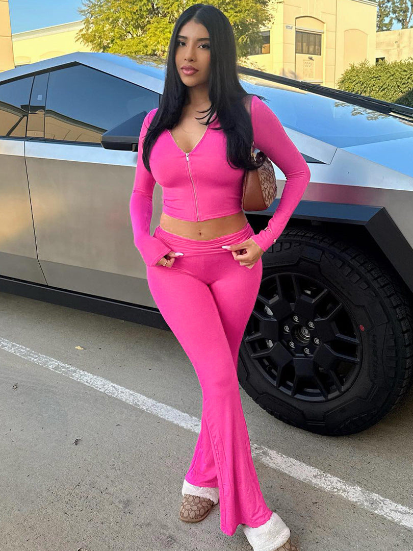 Woman in a bright pink outfit standing in front of a car